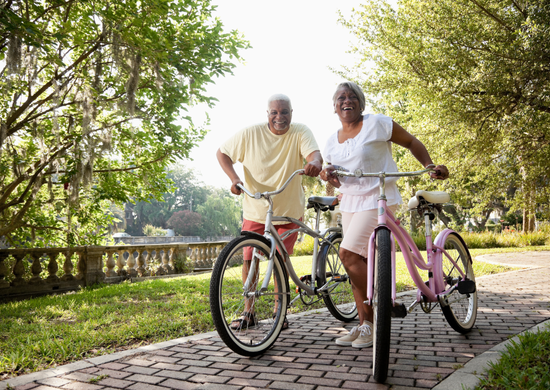man and woman on a path with their bikes laughing